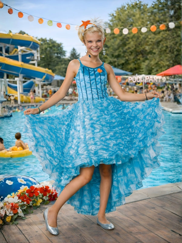 Kids Sharpay musical star tiered blue dress for school plays by The Fancy Dress

Woman in a blue dress standing by a pool with water slides and people in the background